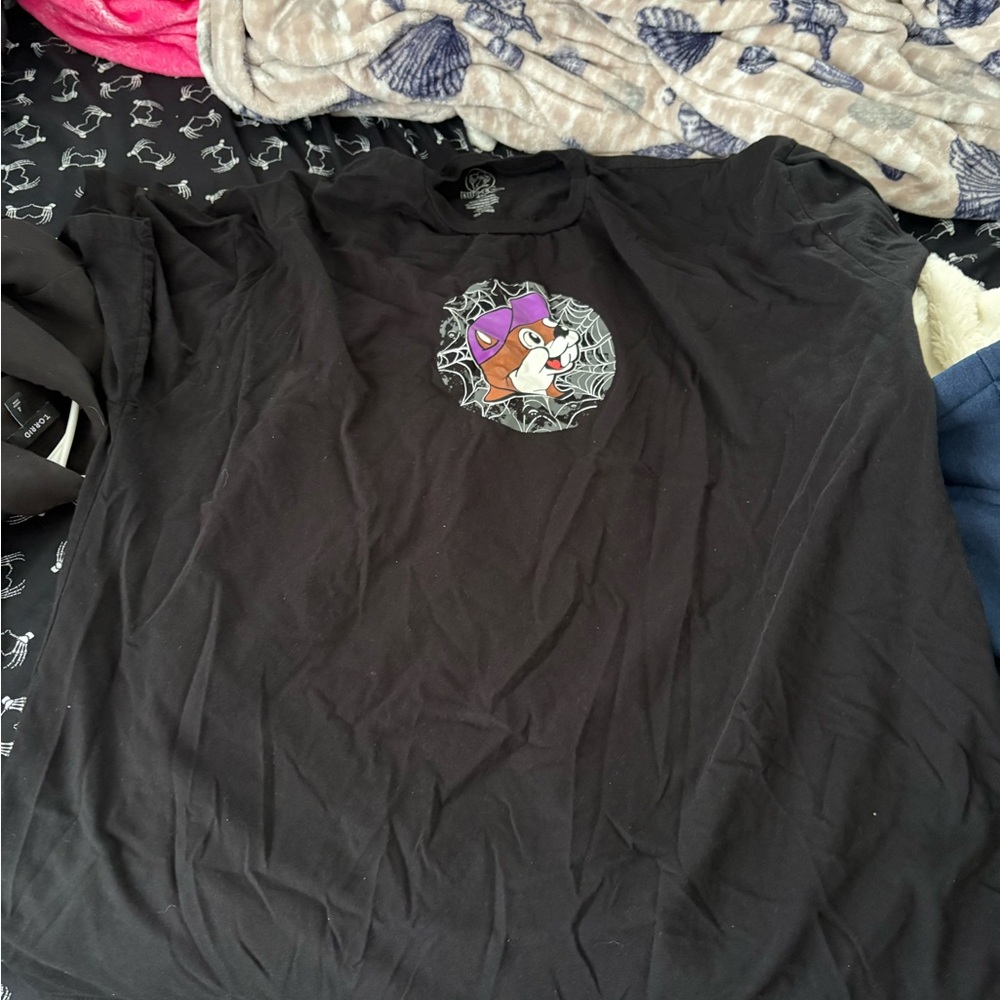 Buc-ee’s Black T-Shirt with Cartoon Character glows in the dark.